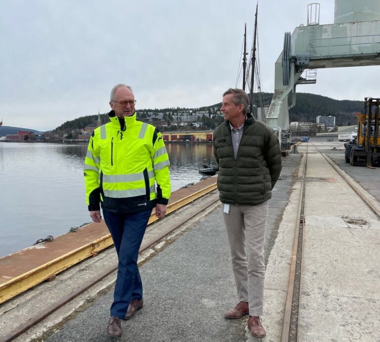 Havnesjef Einar Olsen og konsernsjef Pål Skjaeggestad i Glitre Energi gaar ved siden av hverandre langs havnekaia, ved vannet.