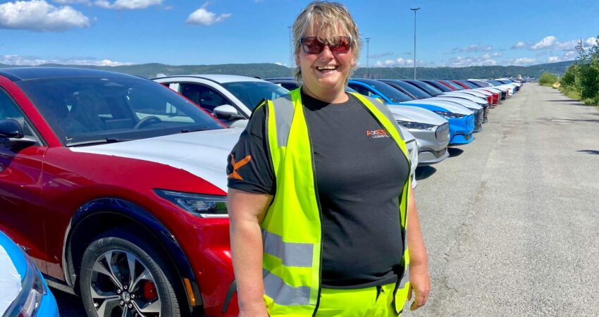 may liss steen eriksen staar foran flere nye biler som har ankommet drammen havn