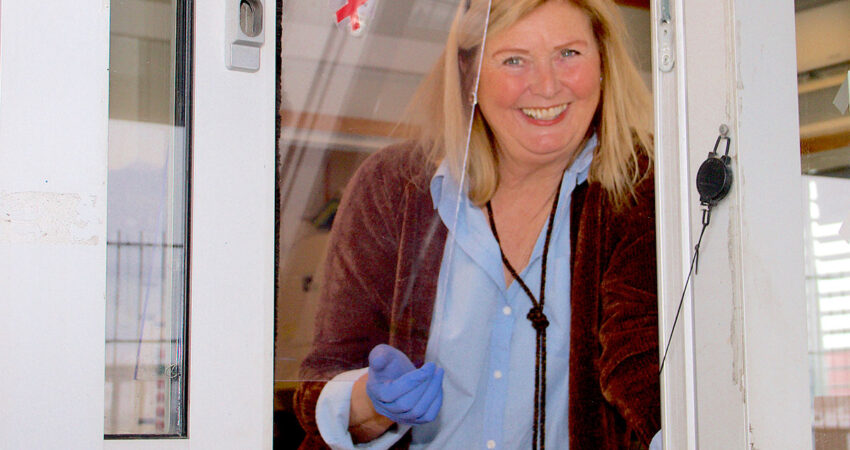 Tone Lise Claussen smiler ut av luken i resepsjonen.