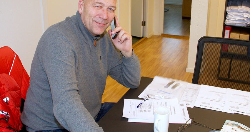 Tom Egil Johannesen snakker i telefonen og smiler mot kameraet.